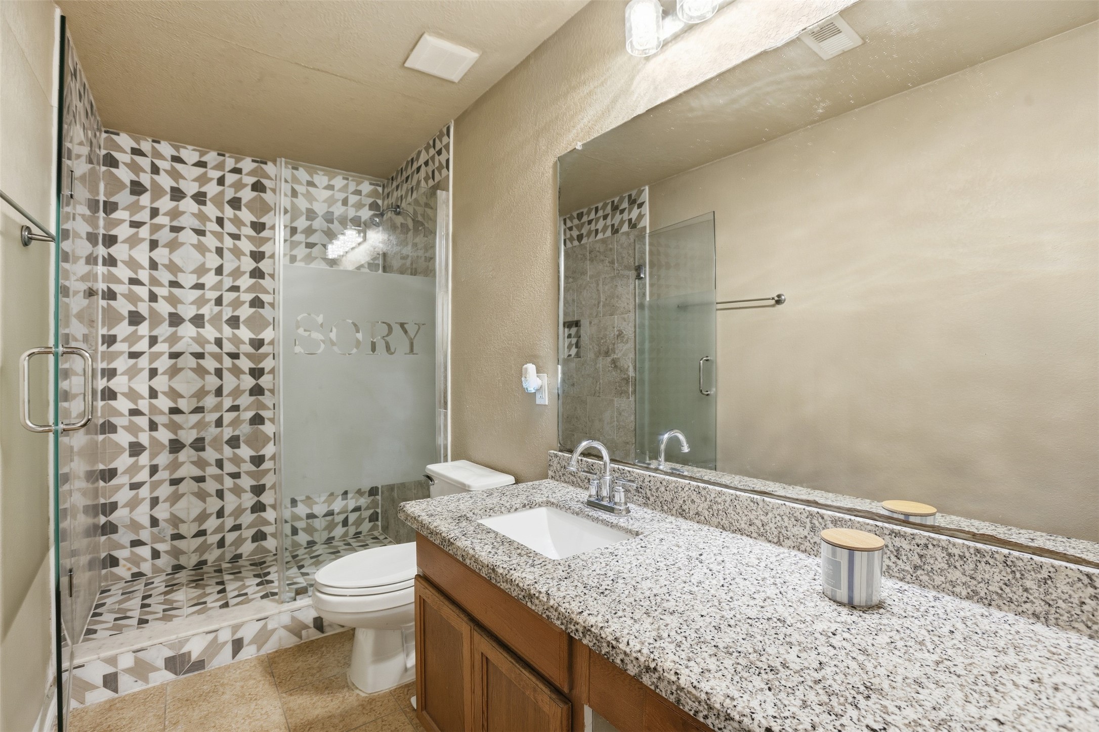 7819 Pasture Spring Lane Cypress, TX 77433 - Photo 19 of 22 a bathroom with a granite countertop sink a toilet and shower