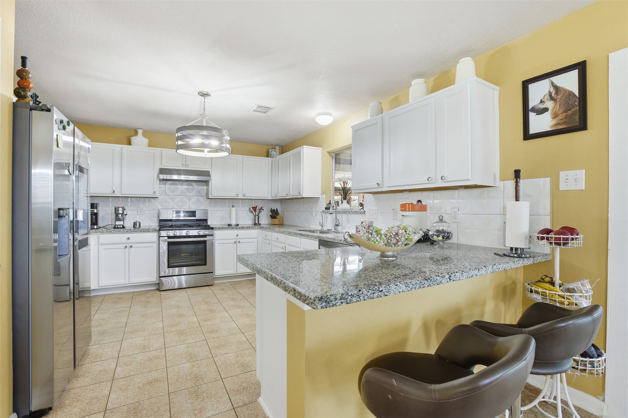 7819 Pasture Spring Lane Cypress, TX 77433 - Photo 6 of 22 a kitchen with a sink a stove and chairs