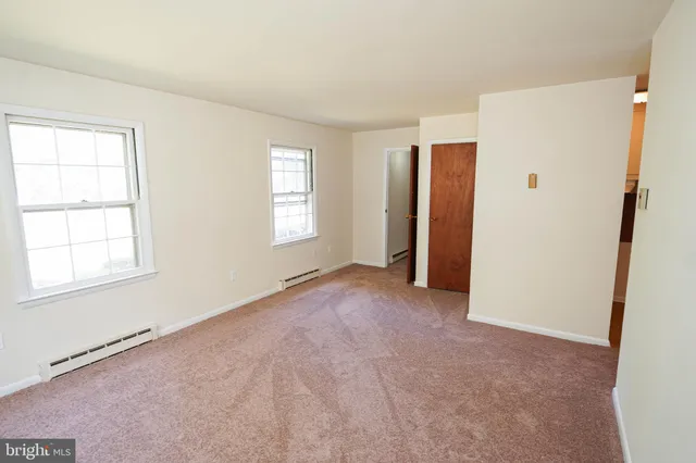 an empty room with windows and closet