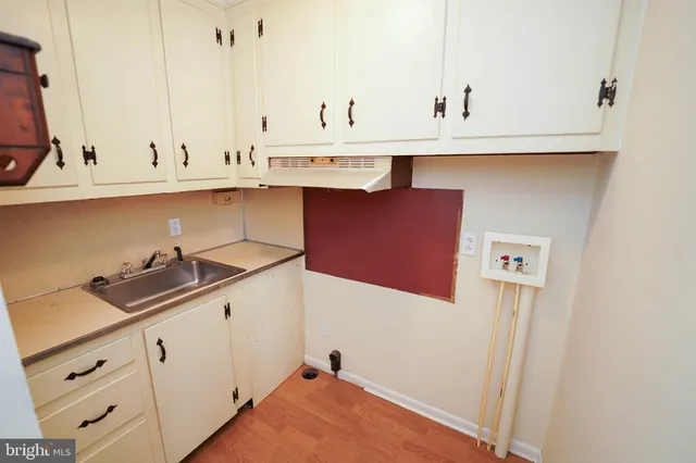 a kitchen with stainless steel appliances a sink a stove and white cabinets