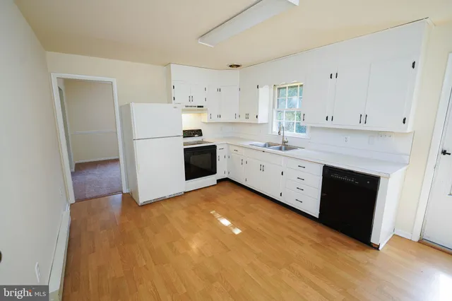 a kitchen with granite countertop white cabinets and white appliances