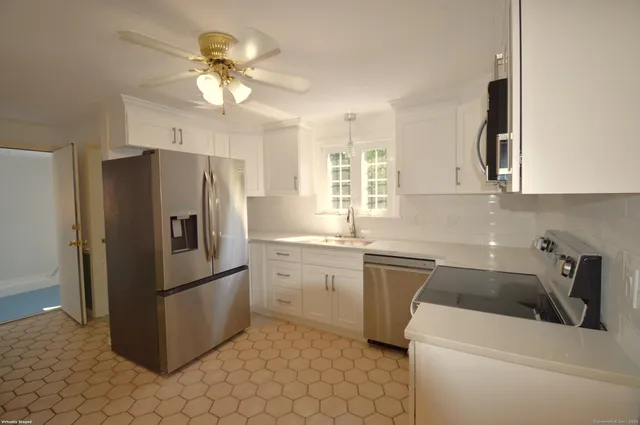 a kitchen with a refrigerator sink and cabinets