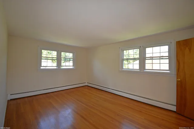 a view of a room with wooden floor and window