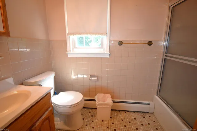 a white toilet sitting next to a bathroom sink and a tub