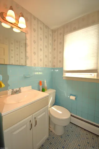 a bathroom with a toilet a sink and a mirror