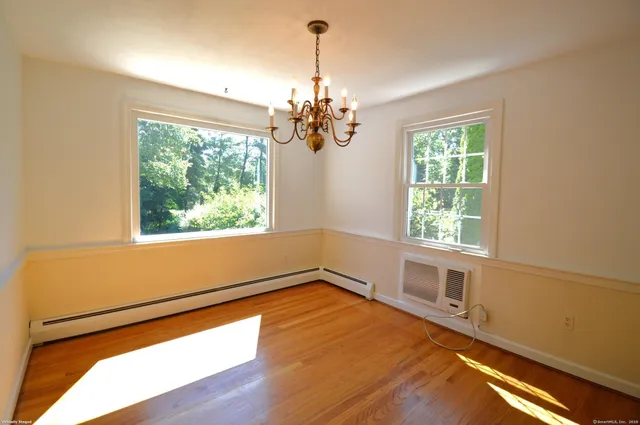 a view of empty room with window and chandelier