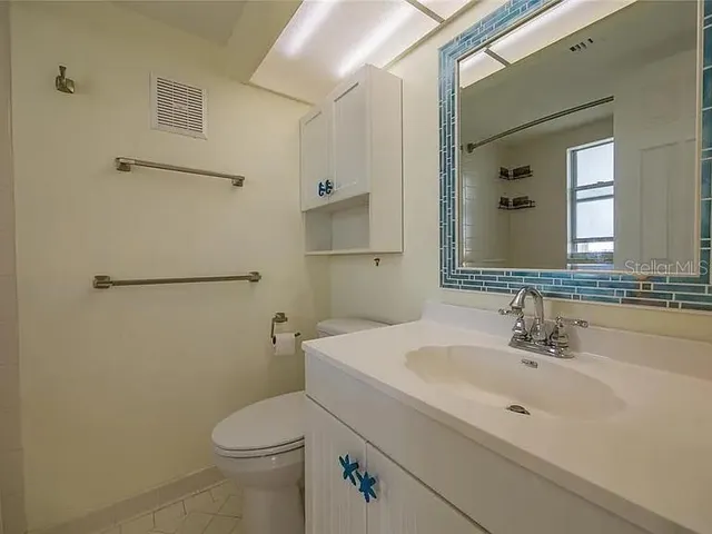 a bathroom with a toilet sink and mirror