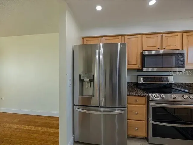 a kitchen with granite countertop white cabinets and white appliances