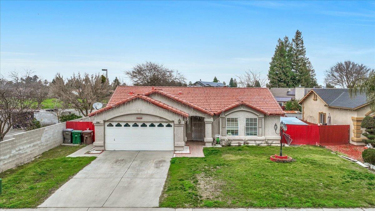 14440 West E Street Kerman, CA 93630 - Photo 2 of 13 a view of a house with a garden and a pathway