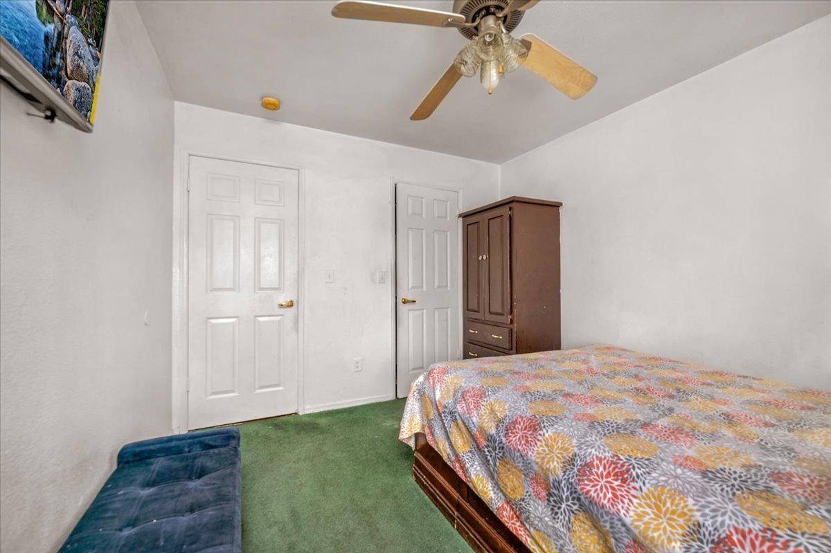 14440 West E Street Kerman, CA 93630 - Photo 8 of 13 a bedroom with a bed and a chandelier