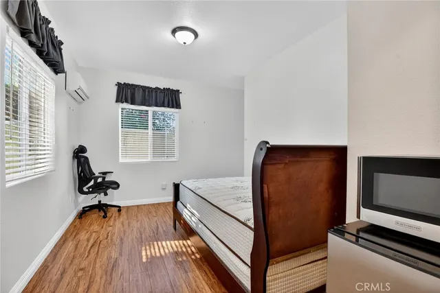 a spacious bedroom with a bed and wooden floor