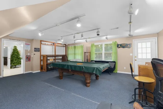 a room with furniture pool table and windows
