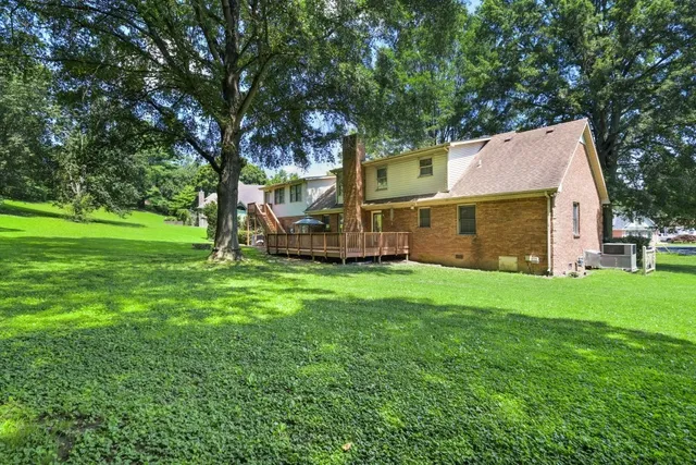 a view of backyard with large trees and a barn