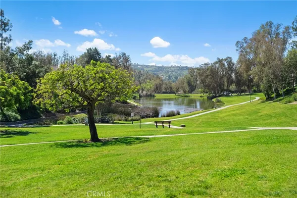 a kitchen with stainless steel appliances granite countertop a refrigerator a sink dishwasher a stove and white countertops with wooden floor