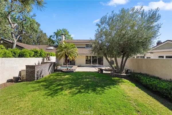 an aerial view of residential houses with outdoor space and trees