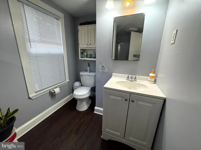 a bathroom with a sink mirror vanity and toilet
