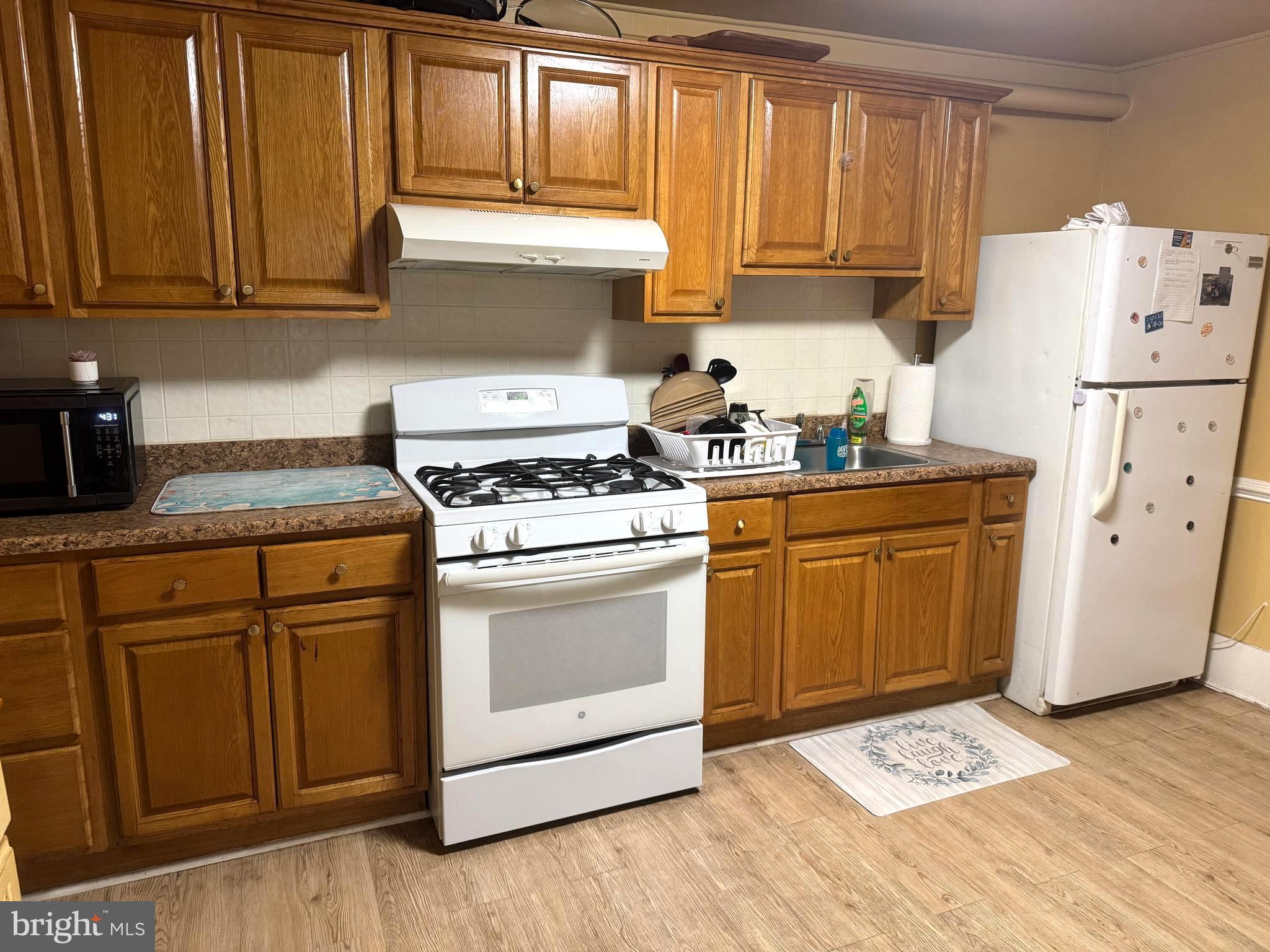 279-281 Arch Street Palmyra, NJ 08065 - Photo 22 of 29 a kitchen with granite countertop wooden cabinets and white appliances