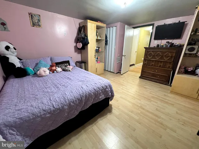 a bedroom with a bed dresser and a flat screen tv