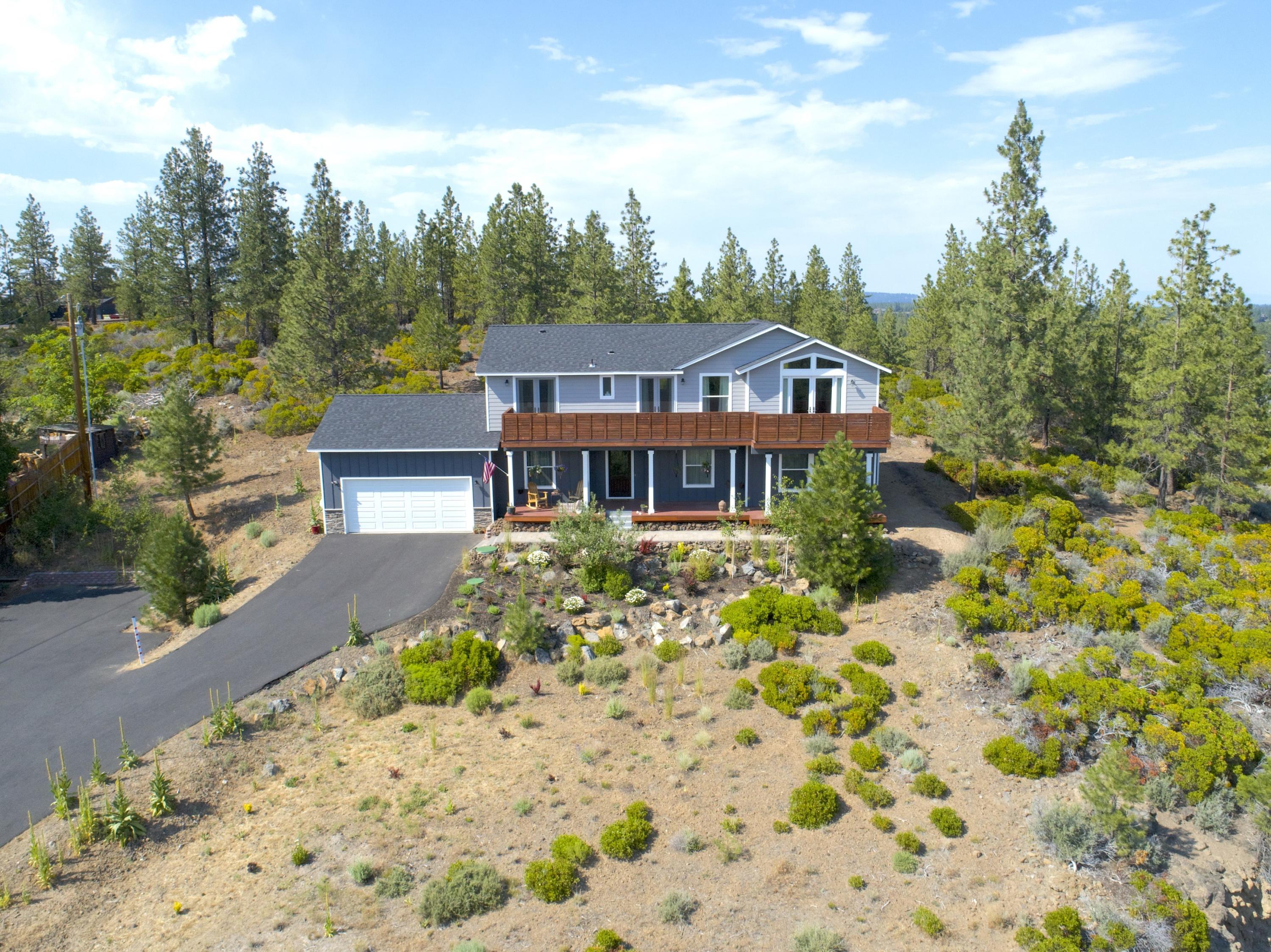 19112 Pumice Butte Road Bend, OR 97702 - Photo 2 of 36 a front view of a house with a garden