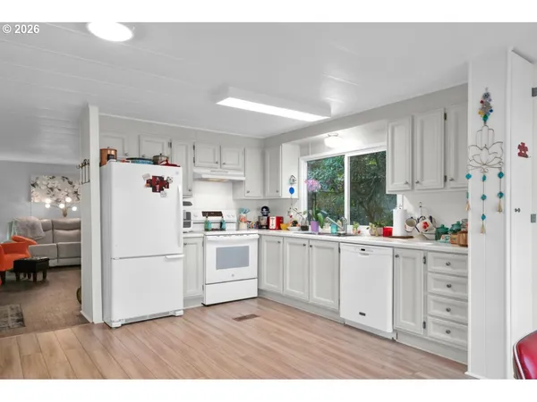 a white kitchen with stainless steel appliances and white cabinets
