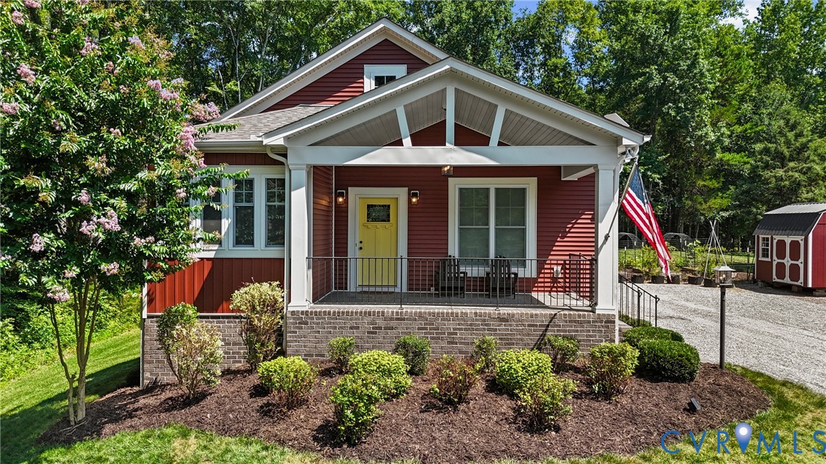 View of front of property with a porch, a storage