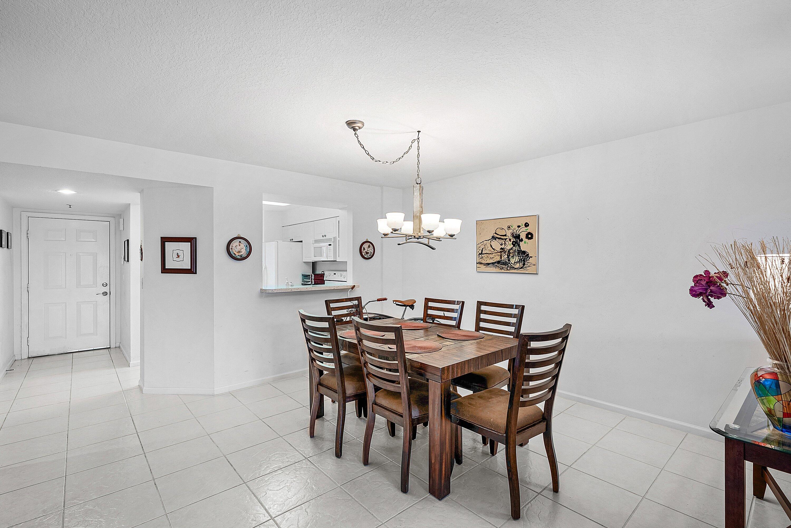 12560 Majesty Circle, Unit 303 Boynton Beach, FL 33437 - Photo 11 of 33 a view of a dining room with furniture and chandelier