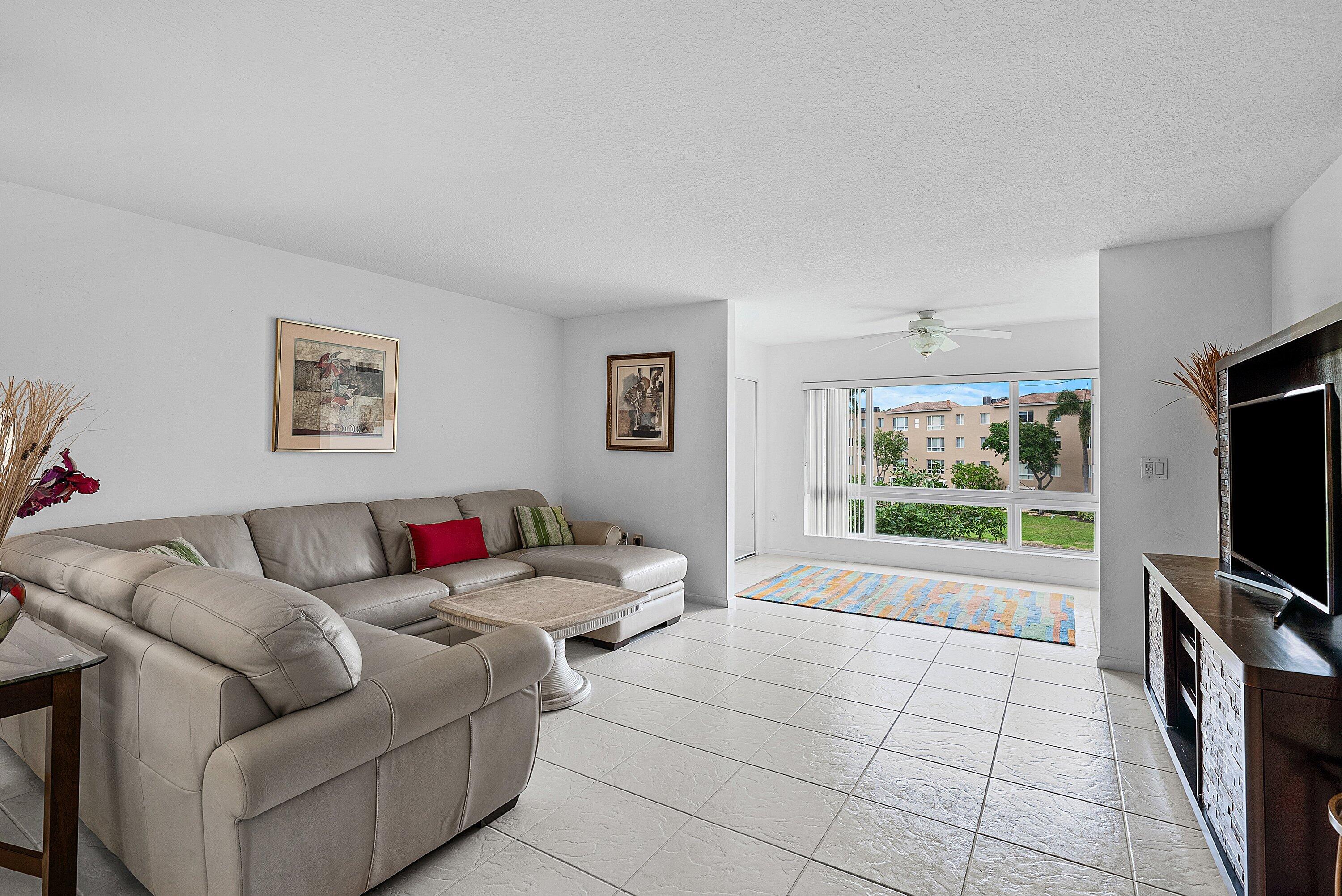 12560 Majesty Circle, Unit 303 Boynton Beach, FL 33437 - Photo 13 of 33 a living room with furniture and a flat screen tv