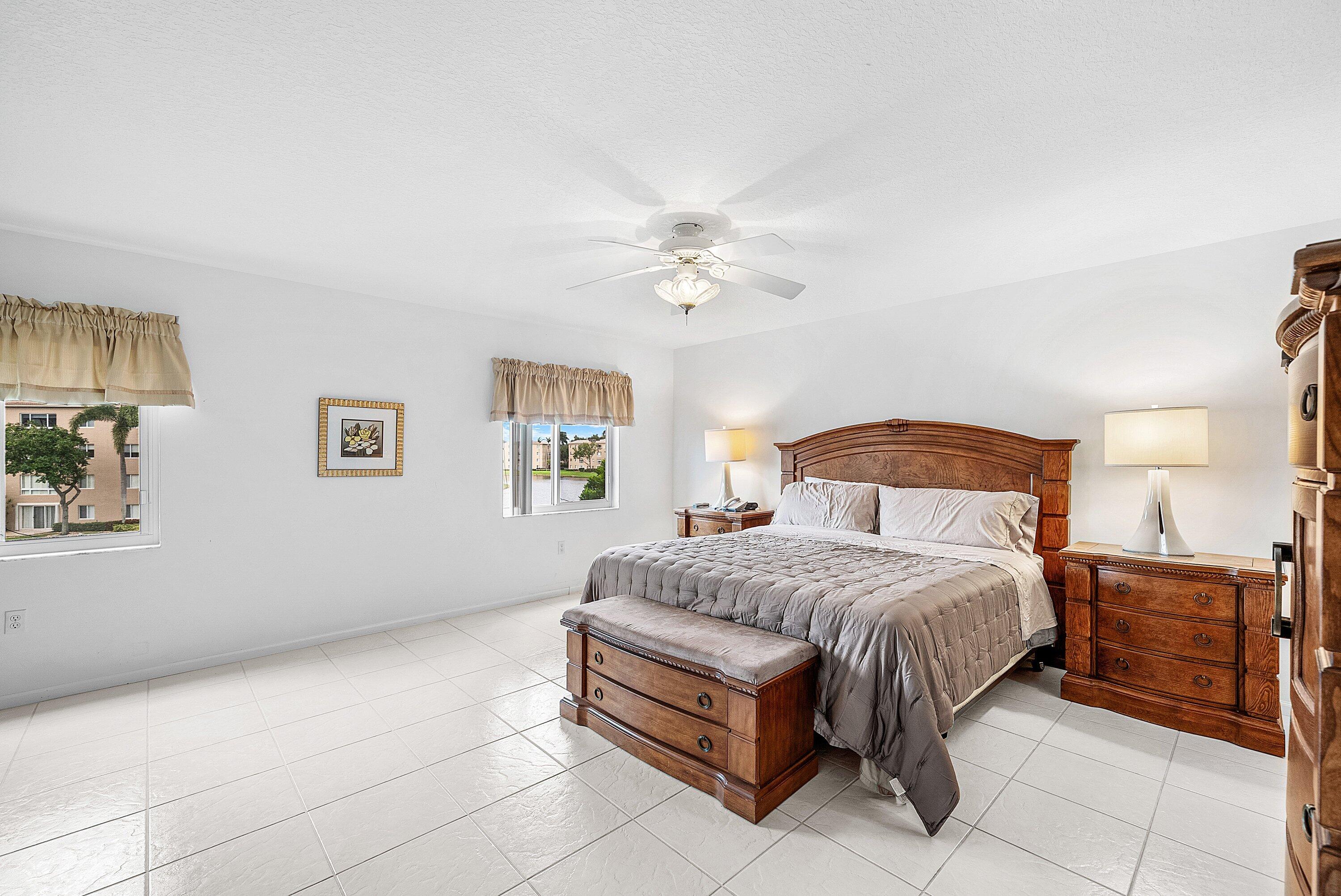 12560 Majesty Circle, Unit 303 Boynton Beach, FL 33437 - Photo 18 of 33 a bedroom with a bed and a chandelier