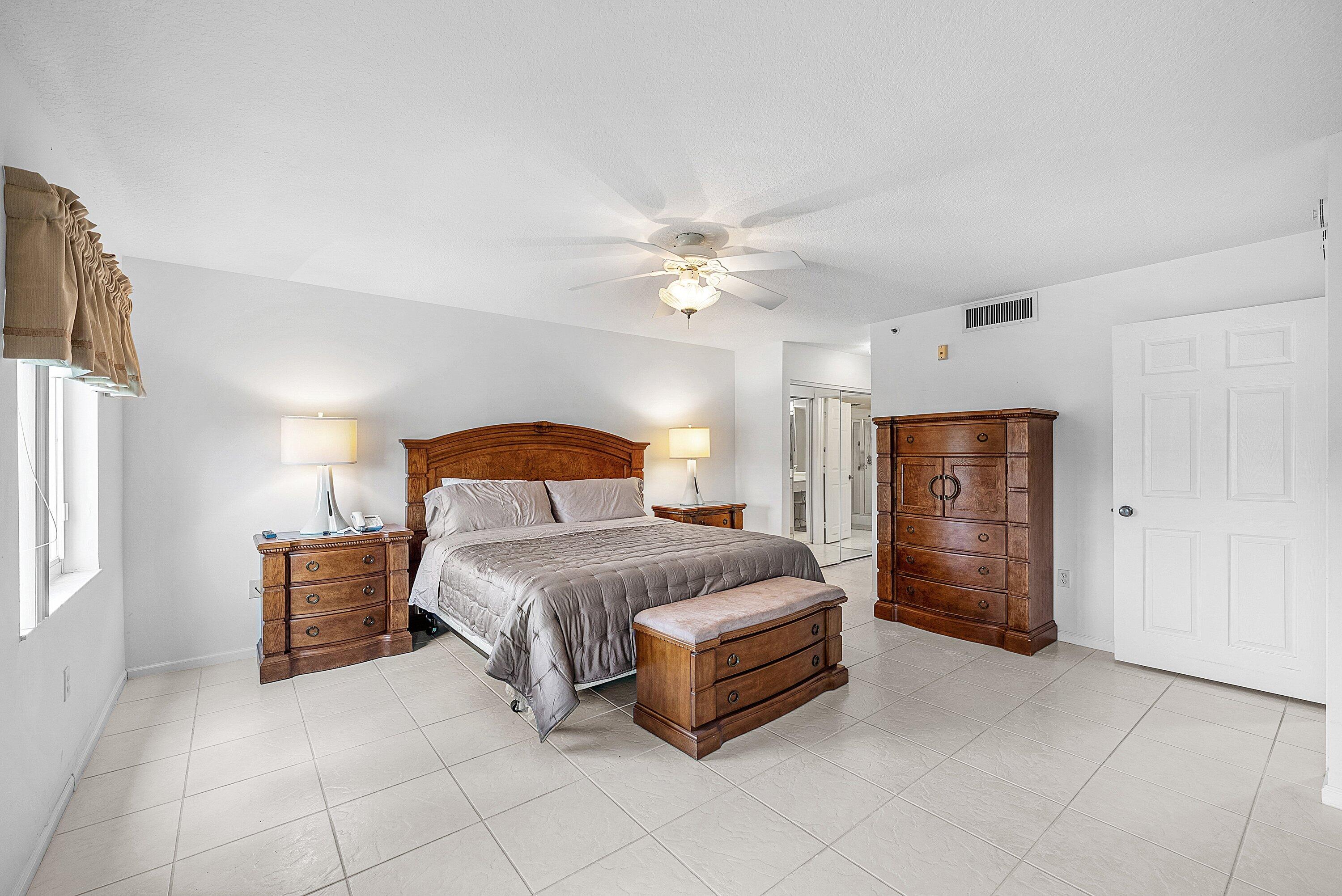 12560 Majesty Circle, Unit 303 Boynton Beach, FL 33437 - Photo 19 of 33 a bedroom with a bed and a chandelier