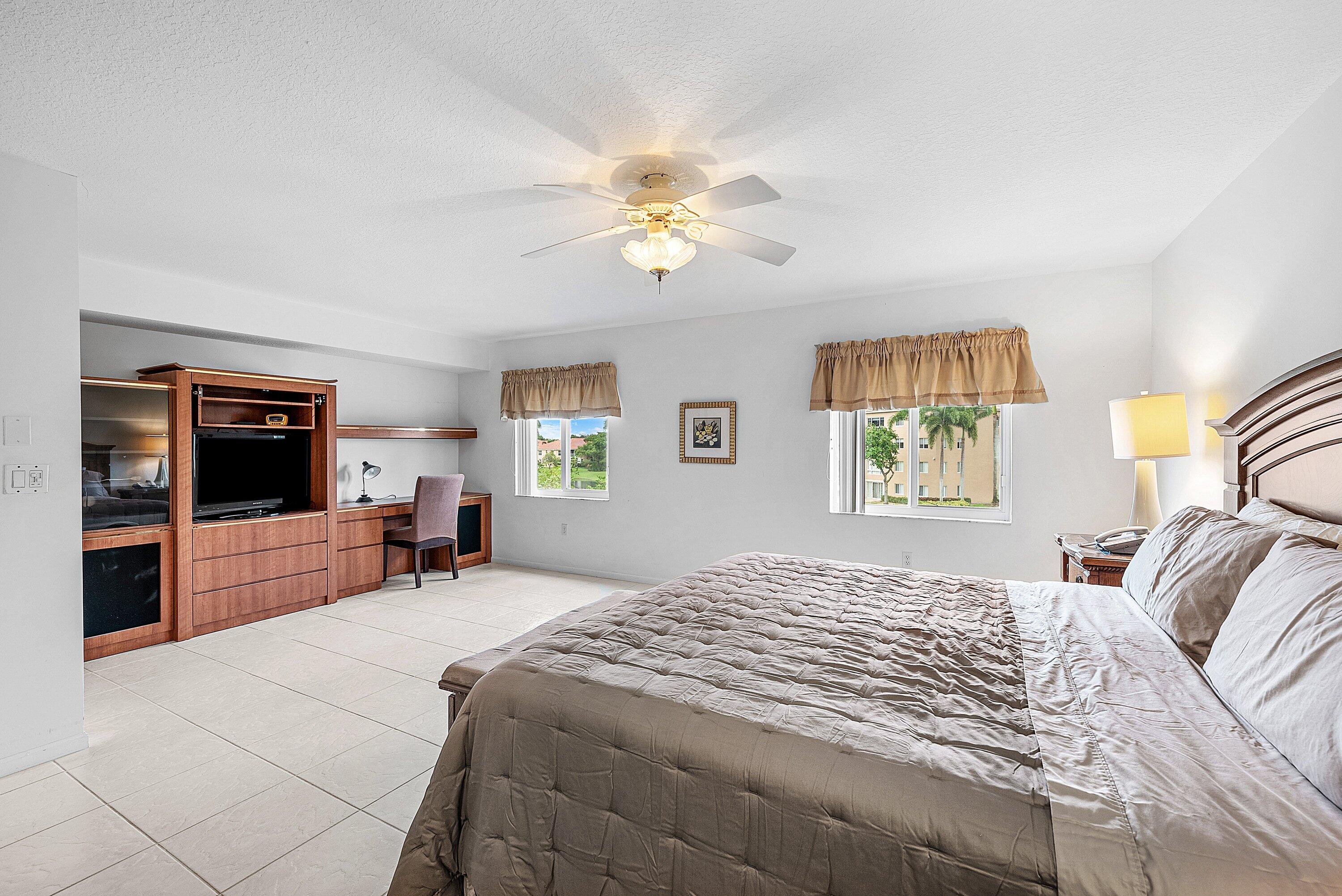 12560 Majesty Circle, Unit 303 Boynton Beach, FL 33437 - Photo 20 of 33 a bedroom with a bed and a chandelier