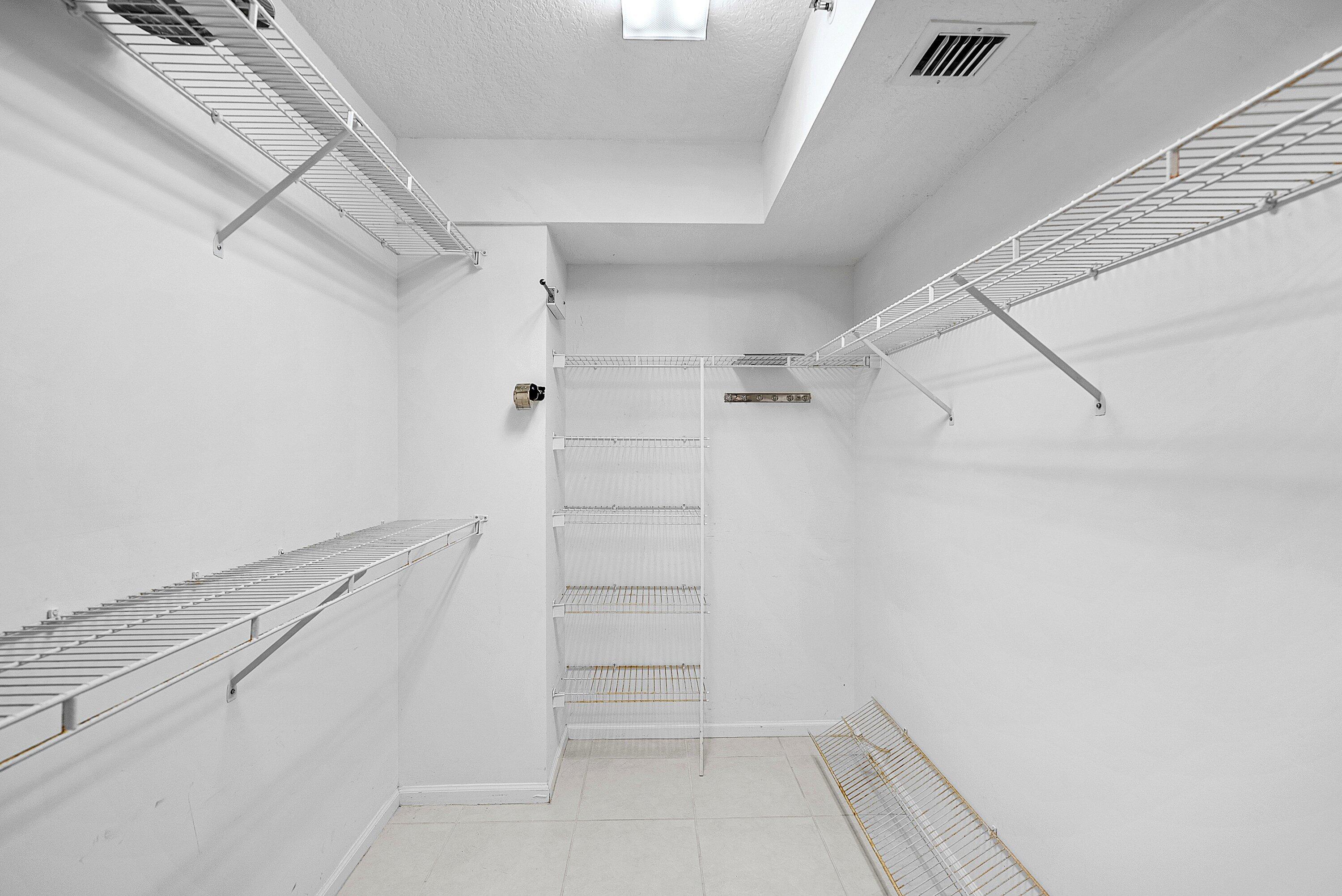 12560 Majesty Circle, Unit 303 Boynton Beach, FL 33437 - Photo 22 of 33 a view of walk in closet with empty racks