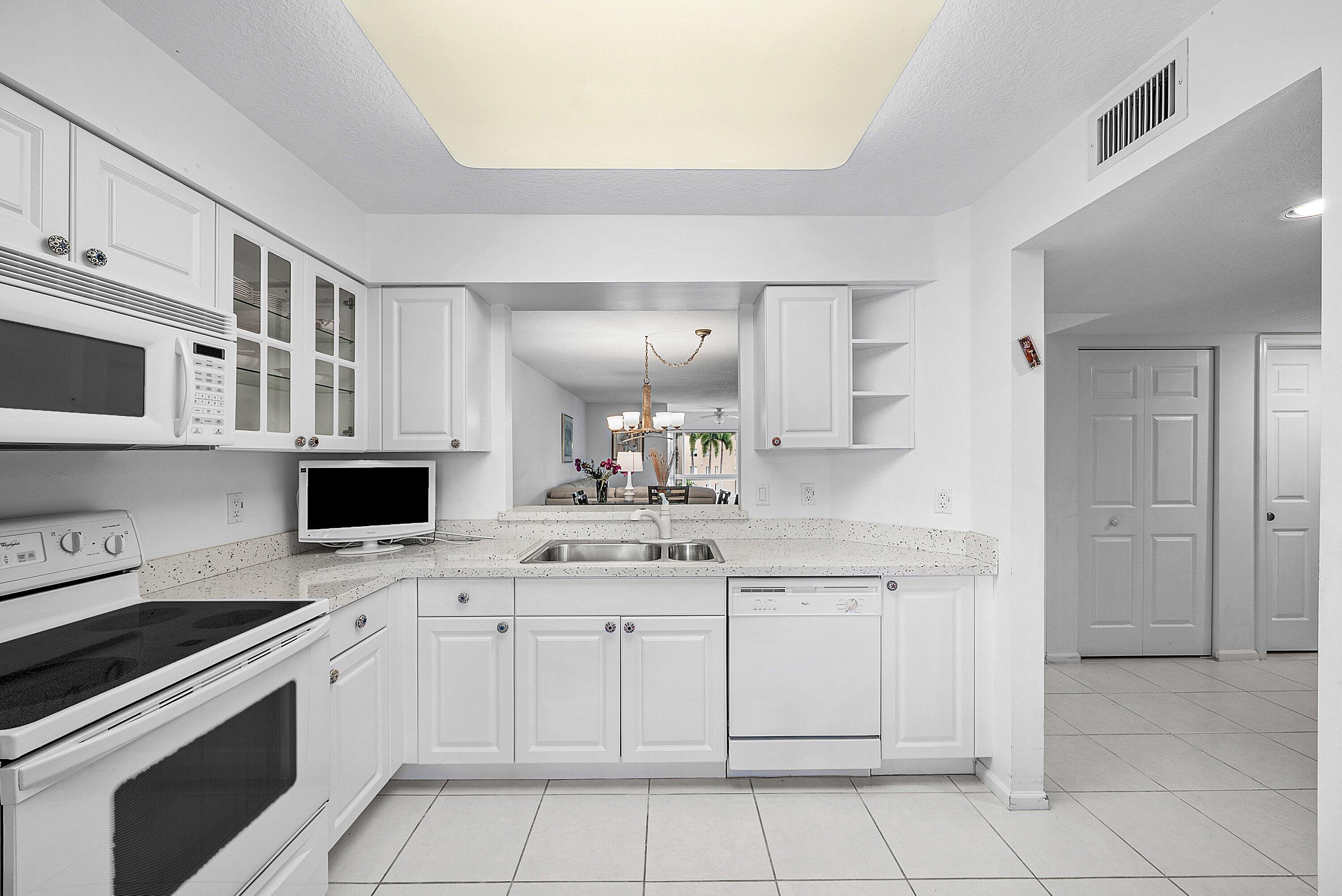 12560 Majesty Circle, Unit 303 Boynton Beach, FL 33437 - Photo 8 of 33 a kitchen with stainless steel appliances granite countertop a sink and a stove
