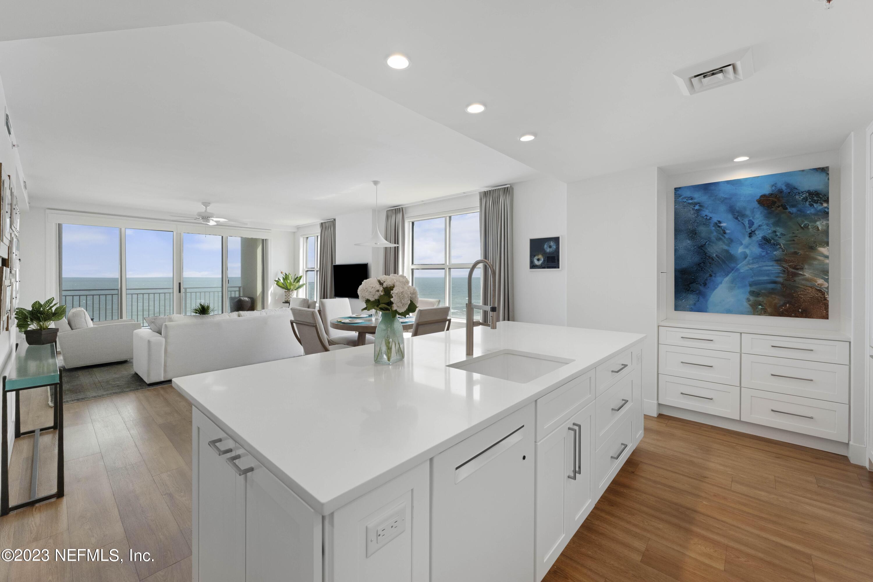 1415 1st Street North, Unit 1005 Jacksonville Beach, FL 32250 - Photo 1 of 17 a large white kitchen with a white countertops a stove and a refrigerator
