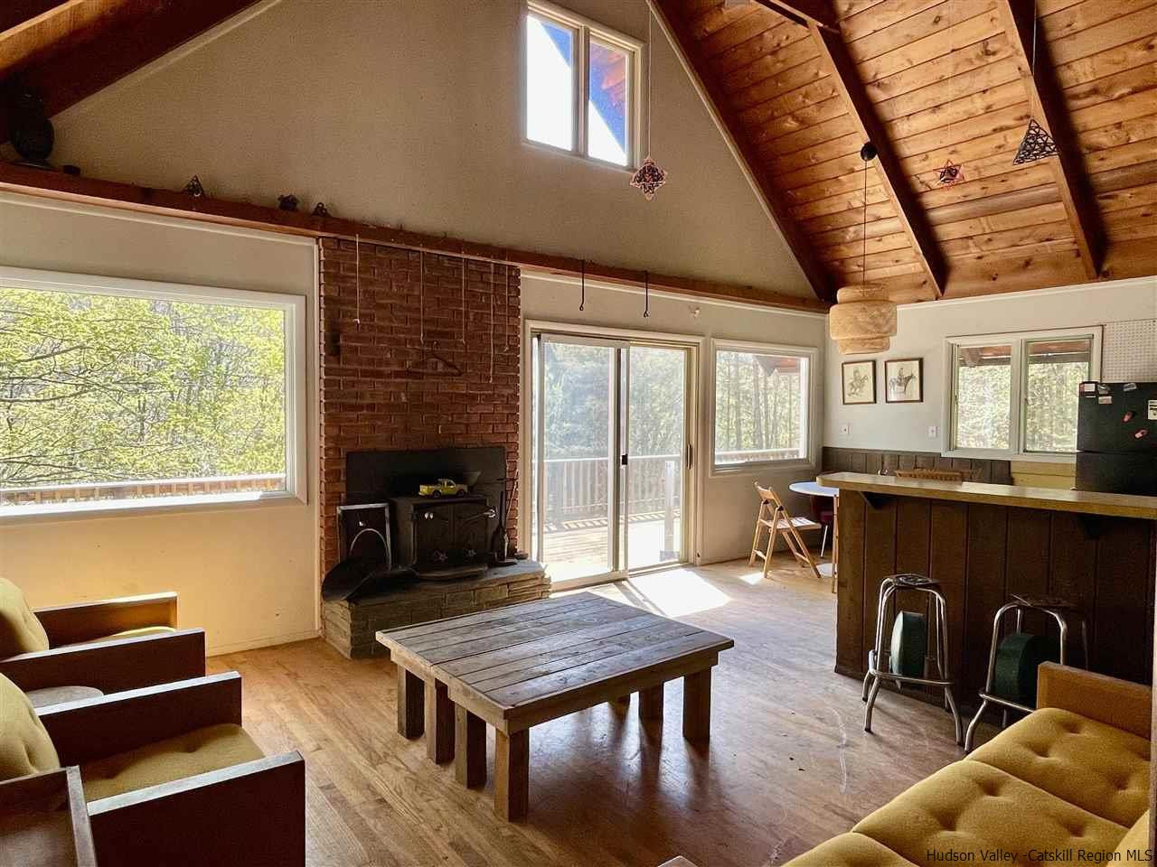 187 Deer Run Road Roxbury, NY 12421 - Photo 11 of 28 a living room with furniture a table and kitchen view