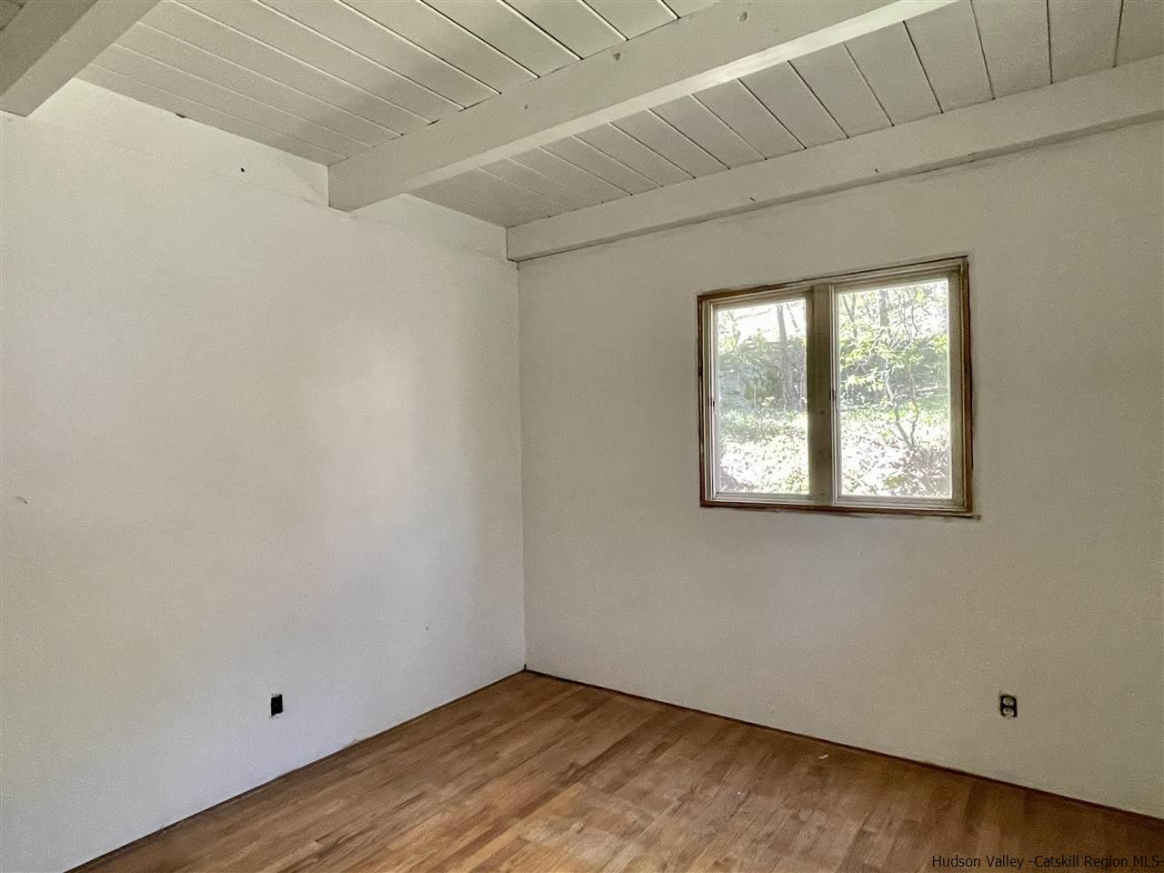 187 Deer Run Road Roxbury, NY 12421 - Photo 19 of 28 a view of an empty room with wooden floor and a window