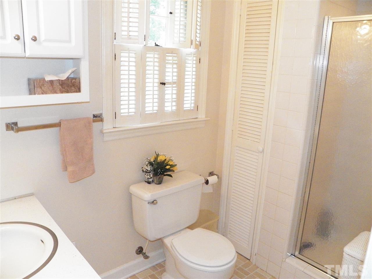 5204 Knollwood Road Raleigh, NC 27609 - Photo 12 of 25 a white toilet sitting next to a bathroom sink and a window