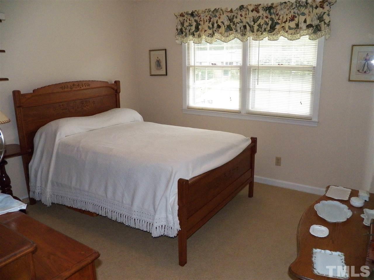 5204 Knollwood Road Raleigh, NC 27609 - Photo 14 of 25 a bed sitting in a bedroom next to a window