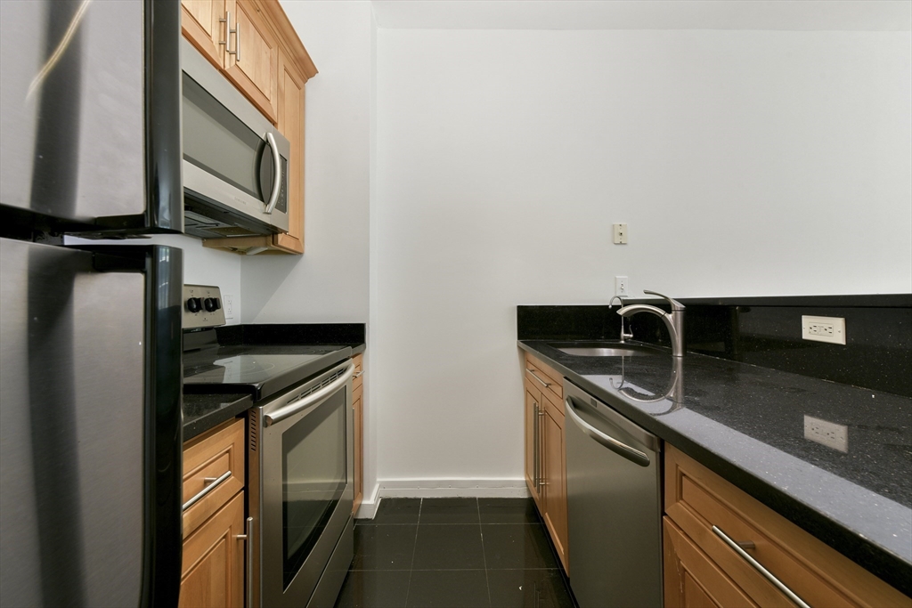 534 Beacon Street, Unit 103 Boston, MA 02215 - Photo 3 of 12 a kitchen with stainless steel appliances granite countertop a sink and a stove