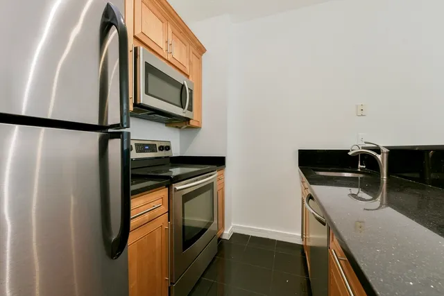 a kitchen with stainless steel appliances granite countertop a refrigerator and a stove