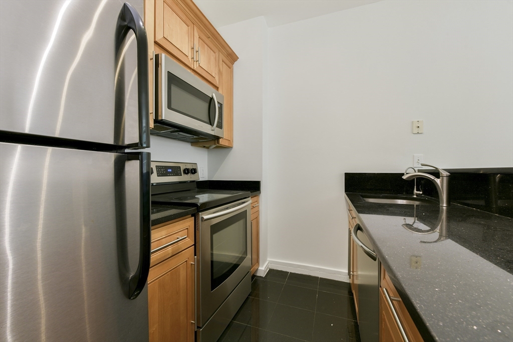 534 Beacon Street, Unit 103 Boston, MA 02215 - Photo 4 of 12 a kitchen with stainless steel appliances granite countertop a refrigerator and a stove