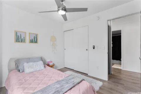 a bedroom with a large bed and wooden floor