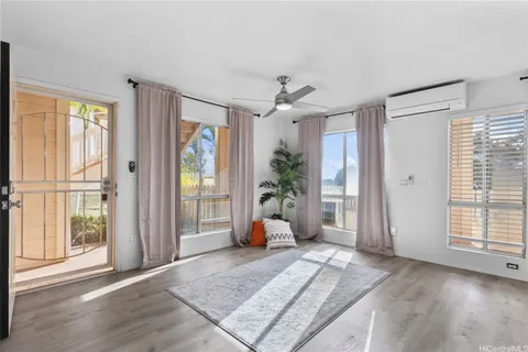 a living room with wooden floor and windows