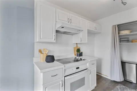 a kitchen with white cabinets and appliances