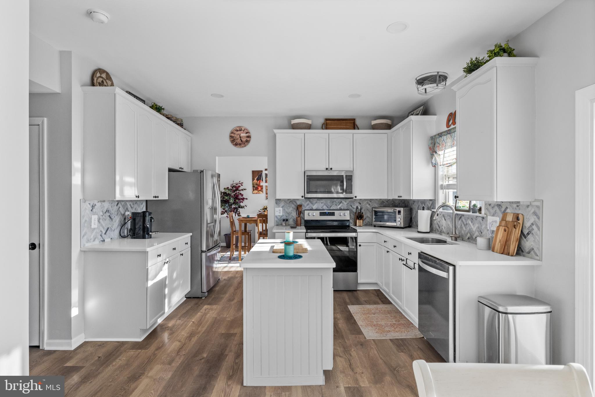 404 Pinnacle Drive Bunker Hill, WV 25413 - Photo 5 of 36 a kitchen with stainless steel appliances a stove a sink dishwasher a refrigerator white cabinets and wooden floor