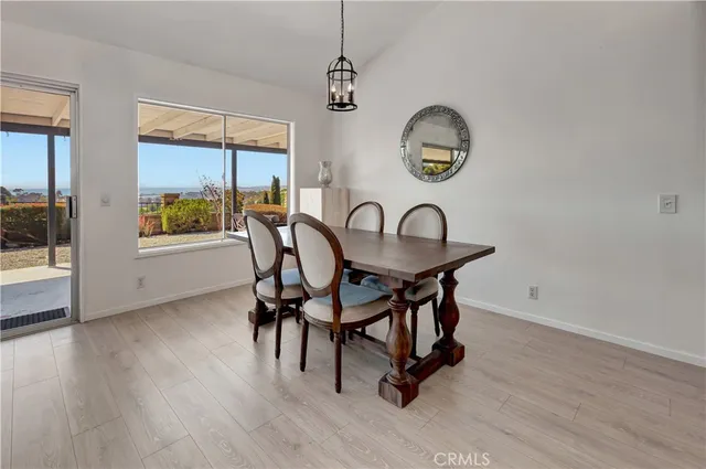 a living room with furniture a large window and wooden floor