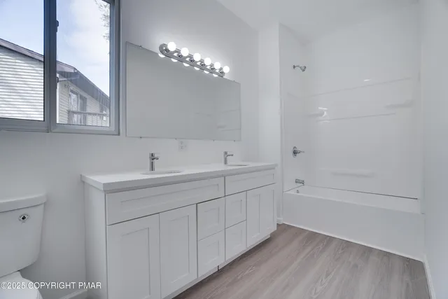 a bathroom with 2 sink tub and a mirror