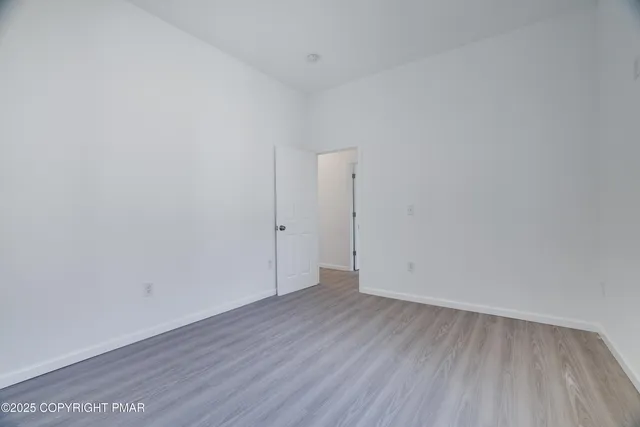 a view of an empty room with wooden floor