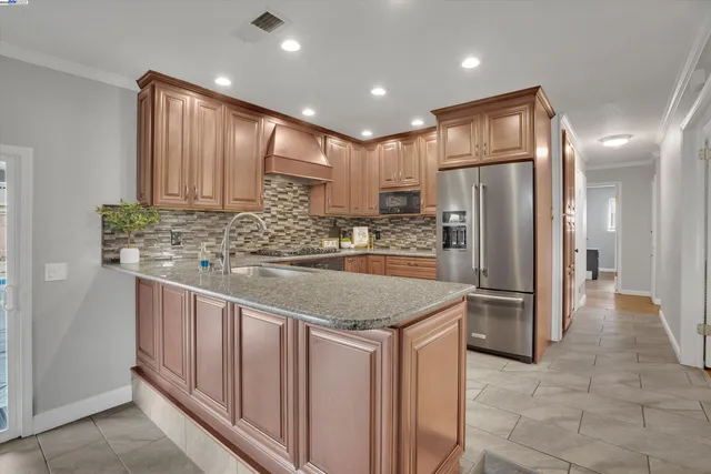 a kitchen with stainless steel appliances granite countertop a refrigerator and a sink