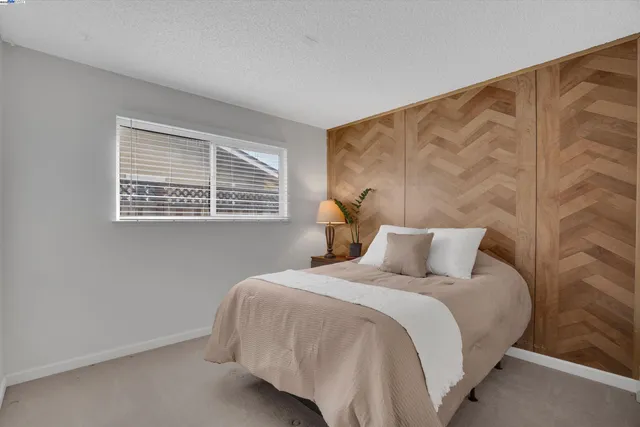 a bedroom with a bed next to a window