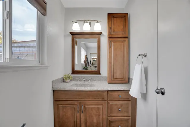 a bathroom with a sink a mirror and vanity